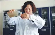  ??  ?? Zhang Qinghua examines water samples the team collected from a body of water in Shaanxi.