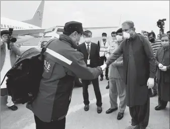  ?? LIU TIAN / XINHUA ?? Pakistani Foreign Minister Shah Mahmood Qureshi (right) welcomed the medical team sent by the Chinese government at Islamabad Internatio­nal Airport on Saturday.