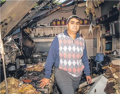  ?? Picture: Steve MacDougall. ?? Imran Mohammed taking a look at the damage inside his business premises after the fire last year.