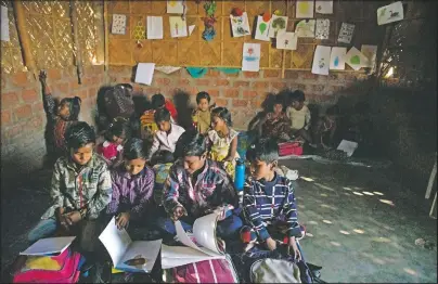  ??  ?? Imradul Ali (second from left) studies with other students at a school near a landfill on the outskirts of Gauhati, India. Coming from a family of scavengers or “rag pickers,” he started scavenging over a year ago to help his family make more money.