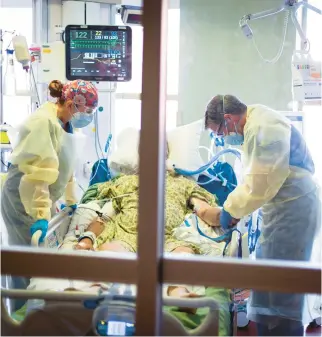  ?? KYLE GREEN/AP ?? Dr. William Dittrich, M.D., looks over a COVID-19 patient in the medical intensive care unit at St. Luke’s Boise Medical Center in Boise, Idaho, in 2021.