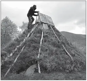  ??  ?? Mikael Vinka stands on top of a traditiona­l goathie home at his Sami Ecolodge near Ammarnas, Sweden. The remote lodge explores the old ways of living in northern Sweden.