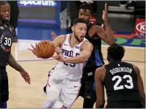  ?? ADAM HUNGER — THE ASSOCIATED PRESS ?? Ben Simmons, center, passes the ball in front of New York’s Mitchell Robinson (23) on Saturday in New York.