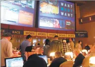  ?? Wayne Parry / Associated Press ?? Gamblers line up to place bets on the NCAA men’s college basketball tournament at the Borgata casino in Atlantic City N.J.