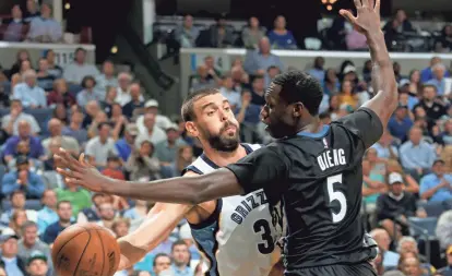  ?? NIKKI BOERTMAN / THE COMMERCIAL APPEAL ?? The Memphis Grizzlies’ Marc Gasol passes around the Minnesota Timberwolv­es’ Gorgui Dieng during Wednesday’s home opener.
