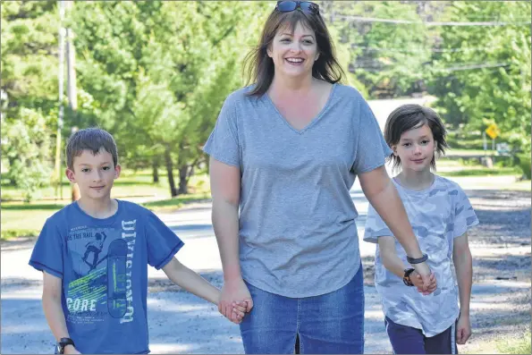  ?? ASHLEY THOMPSON ?? Ravenwood resident Denise Francis, pictured with eight-year-old twins Parker and Aiden, is deeply concerned about impending changes that will result in the eliminatio­n of several school bus stops within the well-travelled subdivisio­n.