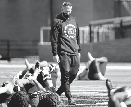  ?? STEPHEN M. KATZ/STAFF ?? Old Dominion football coach Ricky Rahne watches his players warm up before the team’s spring scrimmage Saturday at S.B. Ballard Stadium in Norfolk.