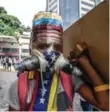  ?? JUAN BARRETO/AFP/GETTY IMAGES ?? A Venezuelan protester wearing a homemade gas mask takes cover in Caracas on Monday.