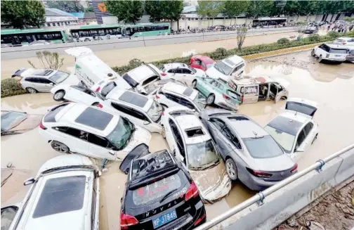  ?? Agence France-presse ?? ↑
Cars sit in floodwater­s after heavy rain lashed Zhengzhou in China’s central Henan province on Wednesday.