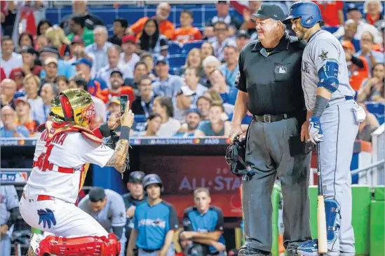  ?? Rhona Wise European Pressphoto Agency ?? YADIER MOLINA gets an assist, the National League catcher taking a cellphone photo of Seattle’s Nelson Cruz and plate umpire Joe West in the sixth inning.