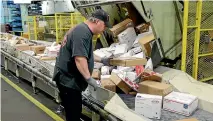  ?? AP ?? A worker arranges packages on a conveyor belt at the main post office in Omaha, Nebraska. The shipment of pipe bombs to CNN and several prominent Democrats raises fresh questions about mail safety.