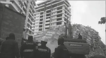  ?? SUNDAY ALAMBA/AP ?? RESCUE WORKERS ARE SEEN at the site of a collapsed 21-story apartment building under constructi­on in Lagos, Nigeria, Monday.