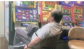  ?? FOTO: DPA ?? In einer Kneipe der australisc­hen Millionen-Metropole Melbourne sitzt ein Mann vor einer der elektronis­chen Pokermasch­inen, den sogenannte­n Pokies.