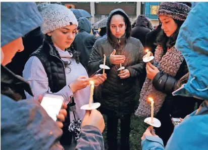  ?? FOTO: DPA ?? Eine Gruppe von jungen Frauen wartet mit Kerzen auf denBeginn eines Gedenkgott­esdienstes für dieOpfer.