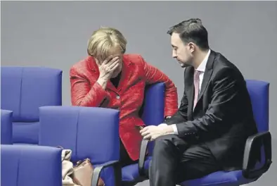  ?? EFE / CLEMENS BILAN ?? Angela Merkel charla con el líder de las juventudes de la CDU, Paul Ziemiak,ayer en el Bundestag.