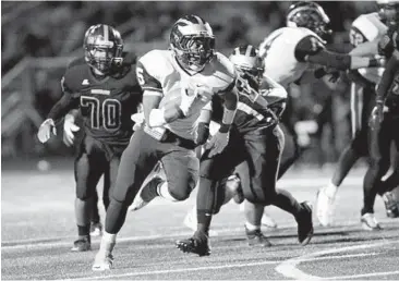  ?? DANIEL KUCIN JR./BALTIMORE SUN MEDIA GROUP PHOTO ?? Howard running back Terrell Charles rushes past Hammond’s Logan White-McCombs in the first half for one of his three touchdowns. The Lions, seeking a 4A North Region playoff berth, led by 20 points at halftime.