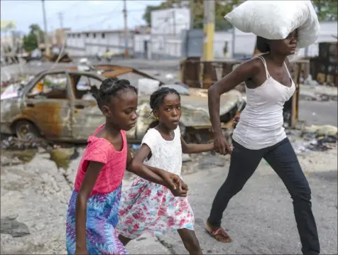  ?? Ramon Espinosa/Associated Press ?? A burned-out car blocks a street in Port-au-Prince, Haiti, as residents evacuate the Delmas 22 neighborho­od to escape gang violence earlier this month. The country is trying to dispel taboos on seeking therapy and talking about mental health.