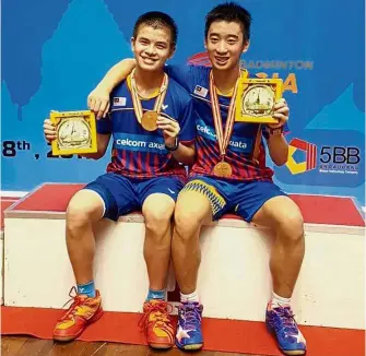  ??  ?? All smiles: Muhd Fazriq Razif (left) and Ong Zhen Yi posing with the gold medals and trophies after winning the boys’ Under-15 doubles event of the Badminton Asia Under-17 and Under-15 Junior tournament in Yangon, Myanmar, yesterday.
