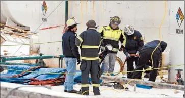  ?? Tom Hindman
Charleston Daily Mail ?? INVESTIGAT­ORS with the FBI and local fire department­s examine the site where a chemical was leaked into West Virginia’s Elk River. Tap water has been declared safe, but bottled water is still being distribute­d.