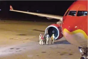  ??  ?? BRISBANE: This picture taken by Calvin Boon yesterday shows fire rescue personnel beside the starboard engine of an AirAsia Airbus A330, after the aircraft on flight D7207 made an emergency landing at the Brisbane Internatio­nal Airport. —AFP