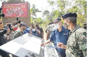  ?? — Gambar Bernama ?? LAWAT PROJEK: Ismail Sabri (dua kanan) ketika melihat pelan rumah yang akan dibina semasa melawat tapak Projek Jiwa Murni sempena sambutan Hari Tentera Darat Ke-88 di Kampung Kuala Triang di Bera, semalam.