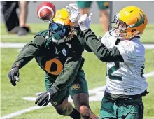  ?? LARRY WONG • POSTMEDIA NEWS ?? Defensive back Jonathan Rose, left, and receiver Greg Ellingson, right, reach for the ball during Edmonton Elks training camp at Commonweal­th Stadium on July 12.