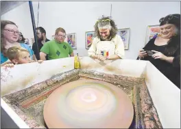  ?? NWA Democrat-Gazette/CHARLIE KAIJO ?? Artist Wayne Coyne (center right) reacts as he gives a spin art demonstrat­ion during his visit to Springdale on Aug. 10.