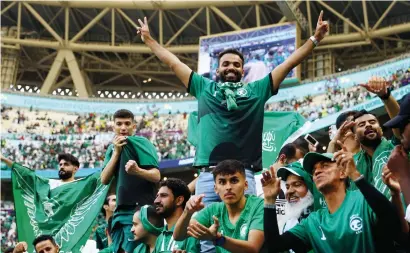 ?? — reuters ?? Saudi Arabian fans celebrate after their team’s stunning upset over Argentina in the Fifa World Cup Qatar match on Tuesday.