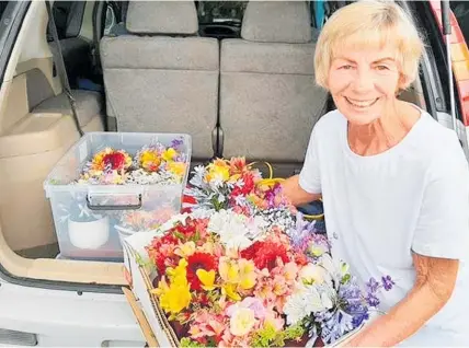  ?? ?? Linda Hart put together beautiful florals from her garden for more than 300 people nominated by the community.