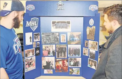  ?? JASON SIMMONDS/TC MEDIA ?? Hard-working forwards Morgan MacDonald, left, and Brock Richard check out the dedication board the Summerside D. Alex MacDonald Ford Western Capitals have for the MHL (Maritime Junior Hockey League) players. Each player and staff member dedicated this year’s post-season run to a special and influentia­l person in their life. The dedication board accompanie­s the team every where during the playoffs, both home and away games.