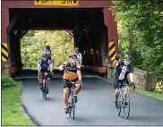  ??  ?? riders cross the covered bridge on Kutz Mill road in the beginning of their 62-mile ride for friend inc.’s 12th annual Brake the cycle of Poverty benefit bike ride on aug. 14.