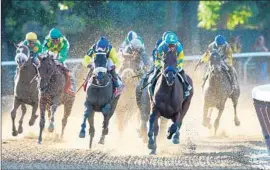  ?? Elsa Garrison Getty Images ?? AMERICAN PHAROAH, under Victor Espinoza, leads the field out of the fourth turn on the way to victory at the Belmont Stakes and the Triple Crown.