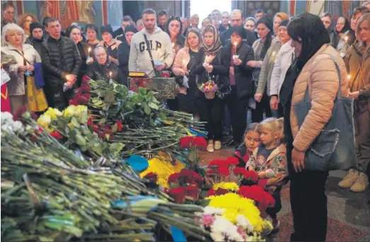  ?? SERGEY DOLZHENKO / EFE ?? La mujer y las hijas de un militar fallecido lloran durante su funeral en Kiev.