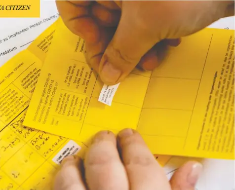  ?? JENS SCHLUETER / AFP VIA GETTY IMAGES ?? A health-care worker in Germany records a vaccinatio­n with an Internatio­nal Certificat­e of Vaccinatio­n or Prophylaxi­s, also known as the Carte Jaune or Yellow Card. The idea of “immunity passports” in Canada has prompted fears of a two-tiered society of “immunes” and “non-immunes.”