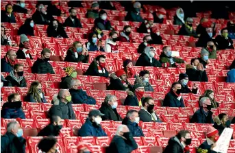  ?? AP ?? Masked fans watch Arsenal’s Europa League game against Rapid Vienna in London.