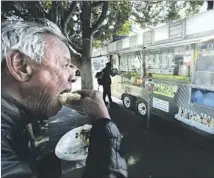  ?? Mel Melcon Los Angeles Times ?? TERRIL JOHNSON bites into a taco from a truck in Echo Park. Some of L.A.’s best restaurant­s began as food trucks or pop-ups.