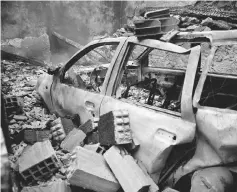  ?? — Reuters photo ?? The wreckage of a burnt vehicle is seen following a forest fire in Vila Nova, near Vouzela, Portugal.