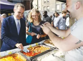  ?? (Stefan Wermuth/Reuters) ?? BANK OF ENGLAND Gov. Mark Carney tests a new polymer 5 pound note as he buys lunch at Whitecross Street Market in London last September.