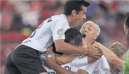  ?? Télam ?? Solari, Viatri y Damonte tapan en el abrazo a Rodríguez, autor del primer gol