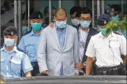  ?? ASSOCIATED PRESS ?? Hong Kong media tycoon Jimmy Lai (center) is escorted by police from his newspaper headquarte­rs Monday.
Lai was arrested on suspicion of collusion with foreign powers, his aide said.