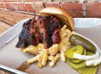  ??  ?? The Brass Monkey sandwich at Burnt Bean includes chopped brisket, sausage and queso mac.