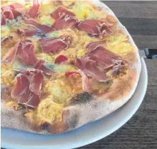  ?? FOTO: NYF ?? Knuspriger Klassiker: die Pizza mit viel Käse und dicken Schinkensc­heiben im Credo in Friedrichs­hafen.