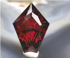  ??  ?? 5.85 ct. “Dark Star” in Malaya Garnet, faceted, carved and photograph­ed by Samantha Rosenberg, GIA AJP.