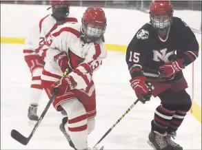  ?? Dave Stewart / Hearst Connecticu­t Media ?? Greenwich's Tess Marciano (13) passes the puck into the zone as New Canaan's Caitlin Tully pursues during a girls ice hockey game at Hamill Rink in Greenwich on Tuesday.