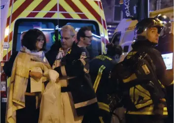  ?? PHOTO AFP ?? Une femme blessée est évacuée par des secouriste­s près de la salle de concert du Bataclan, dans le centre de Paris, le 13 novembre 2015.