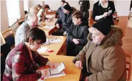  ?? — EPA ?? Civic duty: Voters registerin­g before casting their ballots during the referendum in Riga.