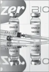  ?? Justin Tallis
/ AFP / Getty Images /TNS ?? A photo illustrati­on shows vials with COVID-19 vaccine stickers attached and syringes with the logo of U.S. pharmaceut­ical company Pfizer and German partner Biontech.