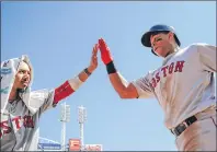  ?? AP PHOTO ?? Boston Red Sox’s Rafael Devers, right, celebrates with Mookie Betts, left, after hitting a solo home run off Cincinnati Reds starting pitcher Jackson Stephens in the fifth inning of a game Sunday in Cincinnati.