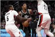  ?? STEVE DYKES — THE ASSOCIATED PRESS ?? The Clippers' Paul George, center, is fouled by Portland's Cam Reddish, left, as he drives the lane during Sunday's win.