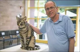  ?? Alex Driehaus/Post-Gazette ?? Howard Ash poses with a statue of his 26-pound cat, Tyson, a graduate of the animal friends program on Saturday during the grand opening of the Howard Ash Animal Wellness Center in Ohio Township.